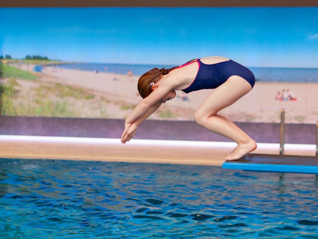 Schwimmerbecken · Mädchen springt vom Einer