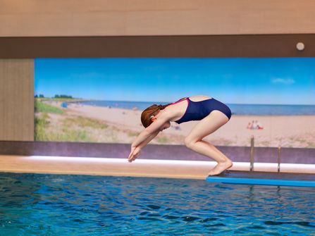 Schwimmerbecken · Mädchen springt vom Einer